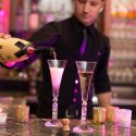 Bartender pouring champagne into two glasses