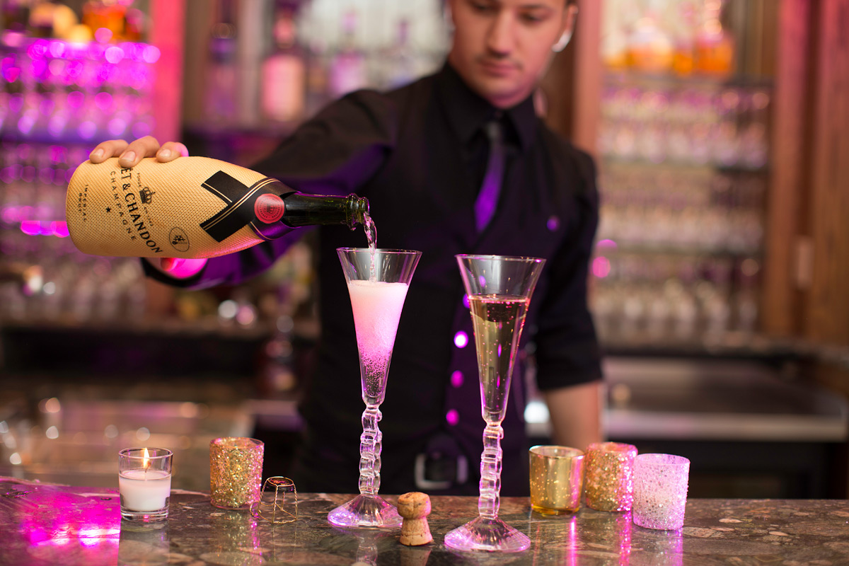 Bartender pouring champagne into two glasses