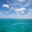 Blue Caribbean waters under lightly clouded sky