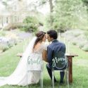 Bride and groom sitting at sweetheart table in formal gardens