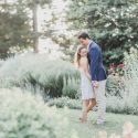 Recently engaged couple walk in formal gardens