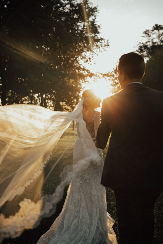 Bride & Groom walking into the sunset with veil flowing at Drumore Estate, Lancaster PA