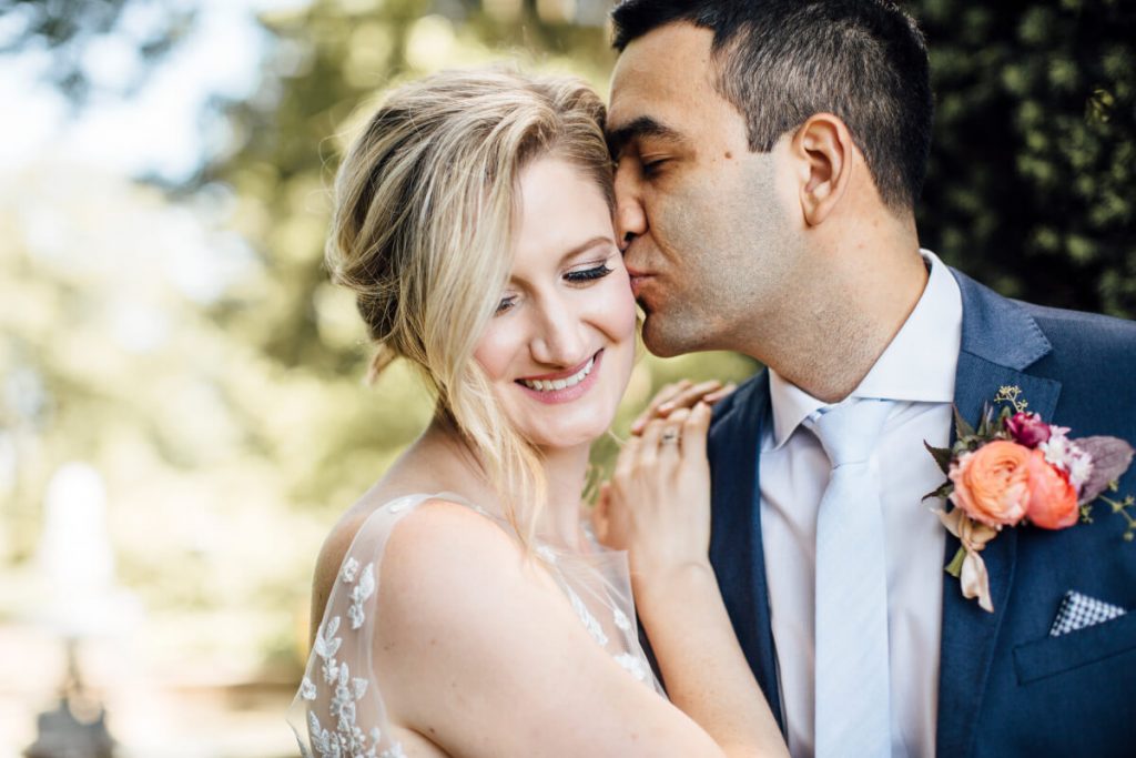 Groom kisses bride on cheek at Drumore Estate, Lancaster PA