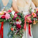 Bridal party holding bouquets behind them