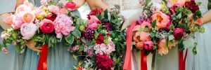 Bridal party holding bouquets behind them