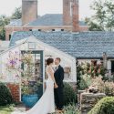 Bride and groom in front of greenhouse at Drumore Estate