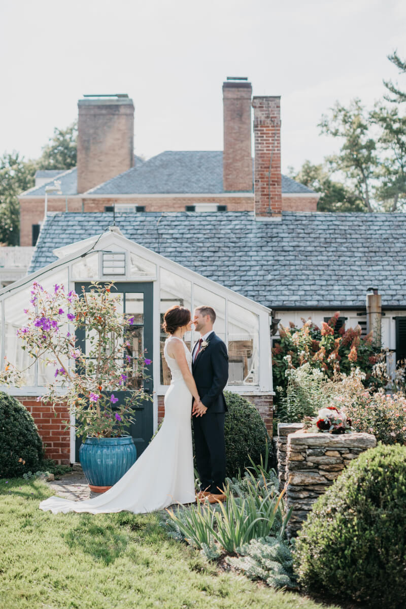 Bride and groom in front of greenhouse at Drumore Estate