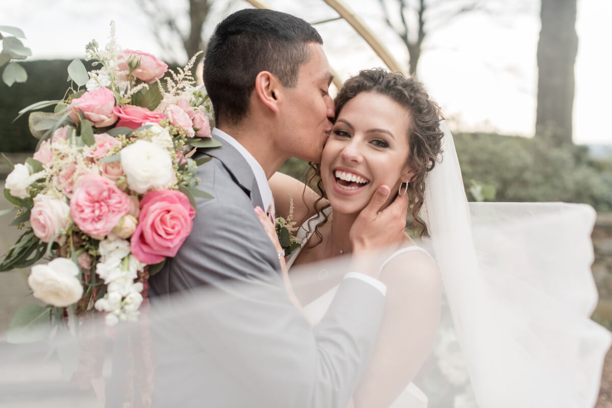 Bride and groom embracing in formal gardens