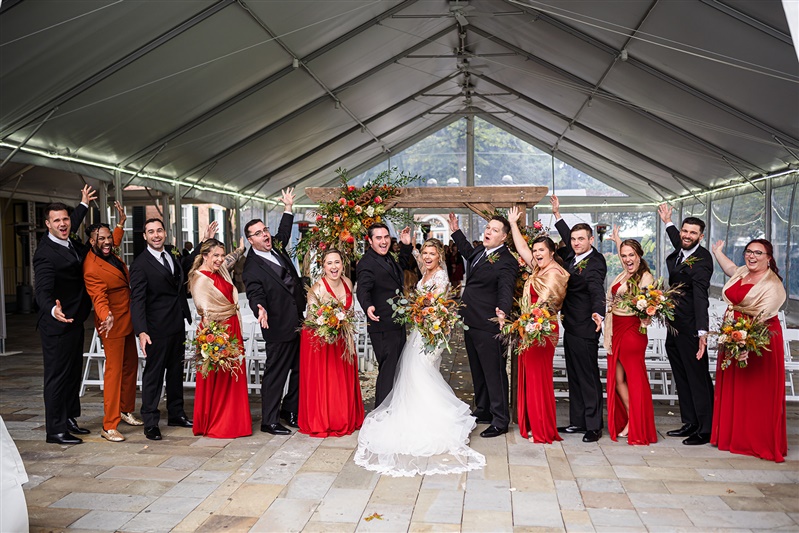 wedding party posing inside grand tent 
