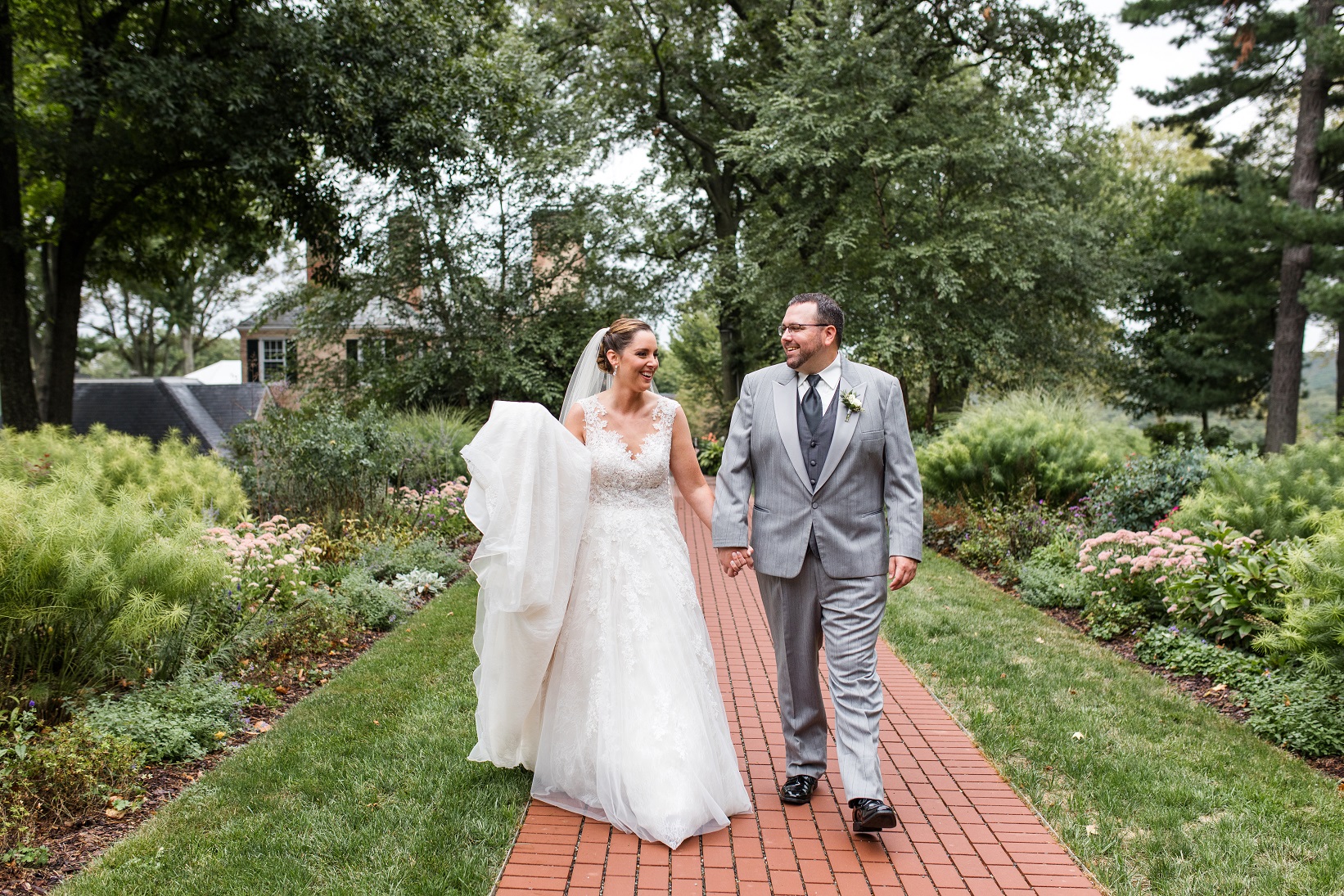 bride and groom walking in garden on their wedding day 