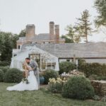 bride and groom kissing in front of wedding venue at Drumore estate